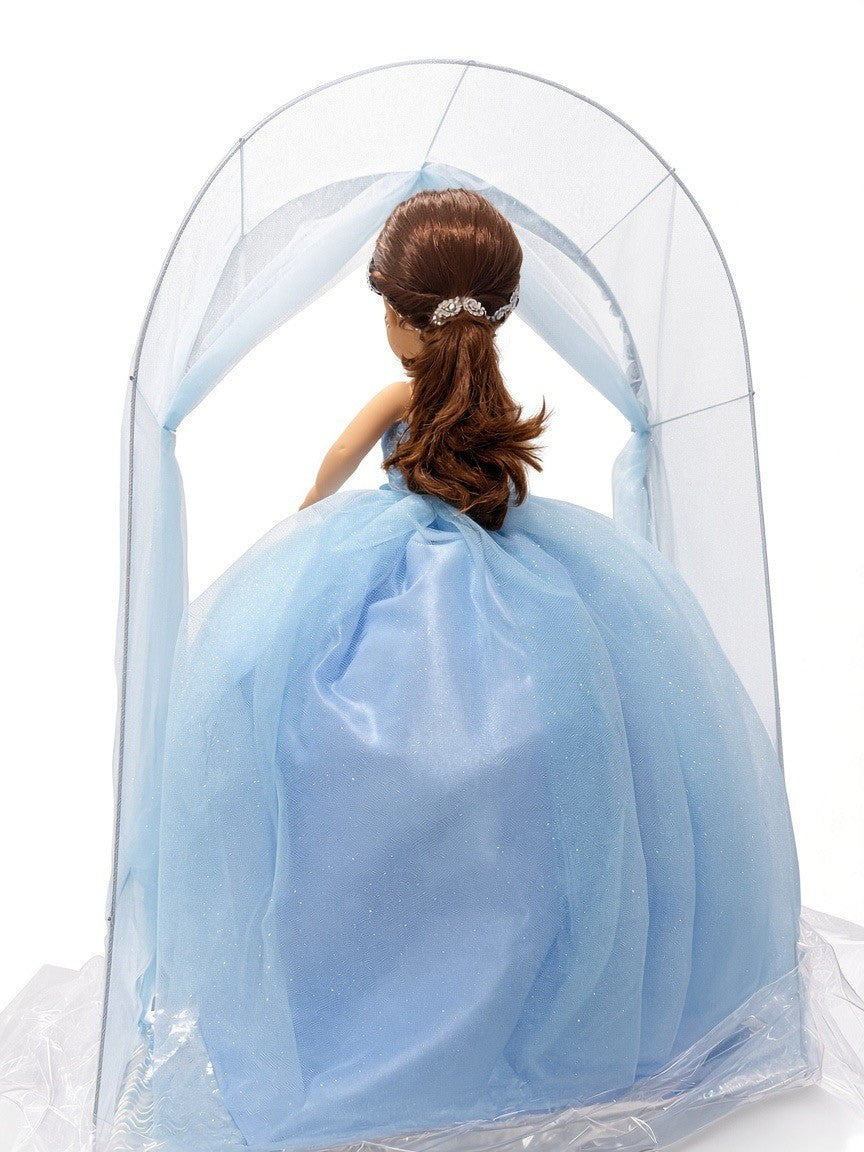 Blue última muñeca back view showing half-up hair with rhinestone clip